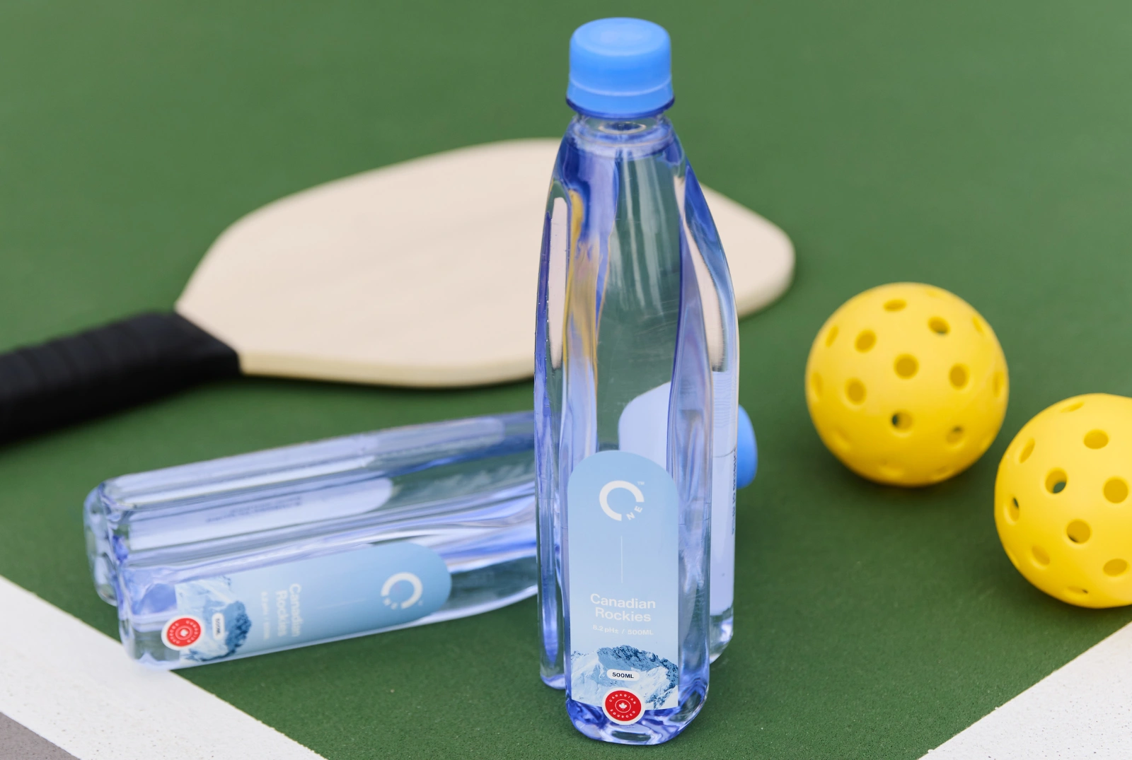 Two One Water bottles on a pickeball court.
