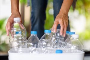 A person collecting and separating recyclable plastic bottles.