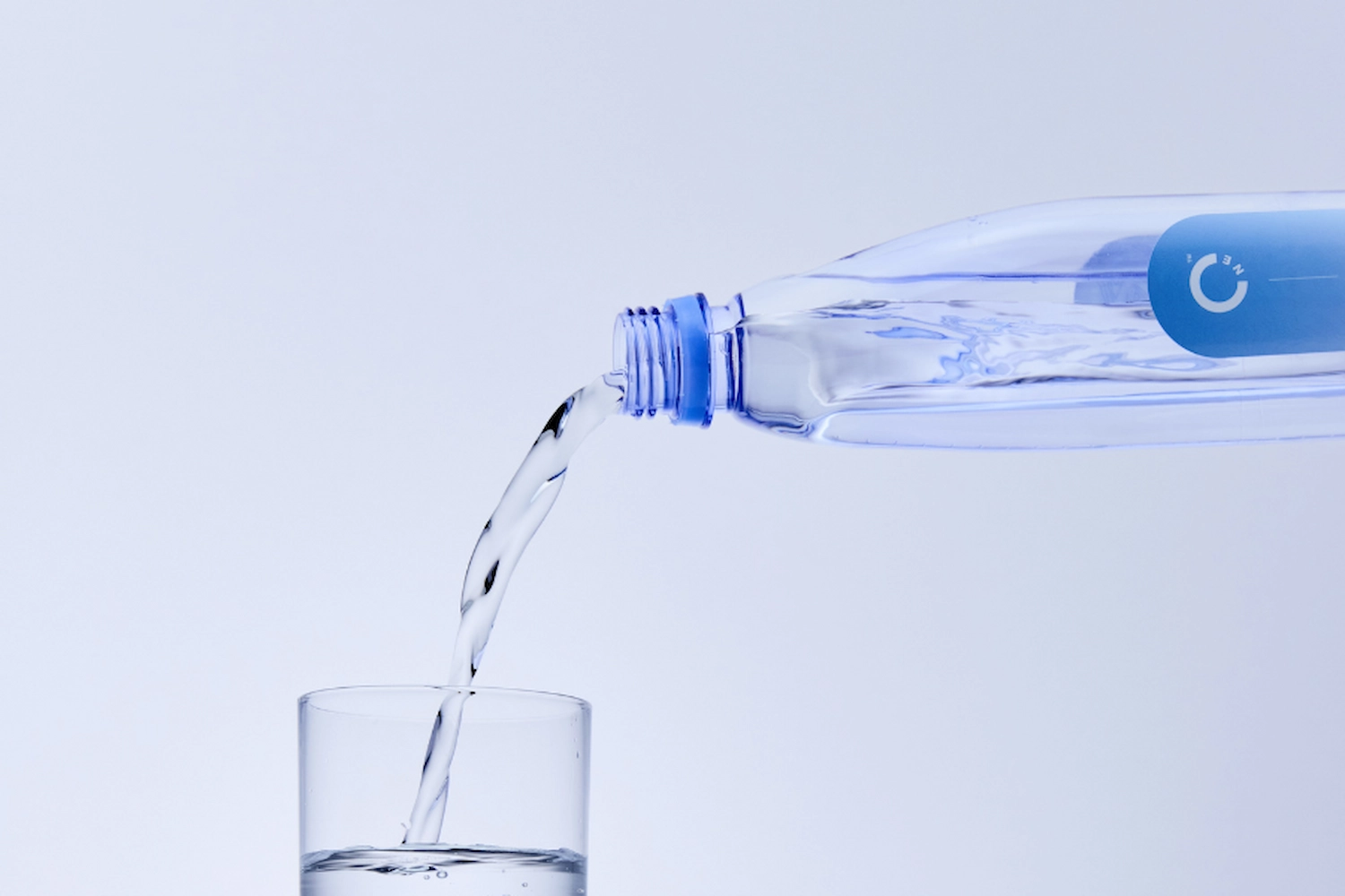 Premium spring water pouring from a bottle into a glass.