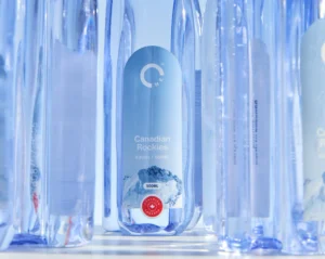 Closeup of a forward-facing One Water bottle in between rear-facing bottles.